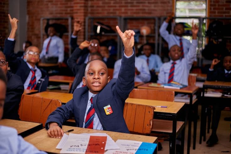 Classroom with students raising their hands